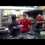 Fast food restaurant kitchen with workers.