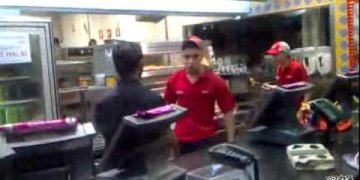 Fast food restaurant kitchen with workers.