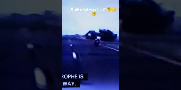 Motorcyclist riding on dimly lit road.