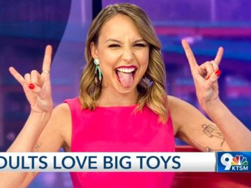 Woman in pink making rock gesture on TV