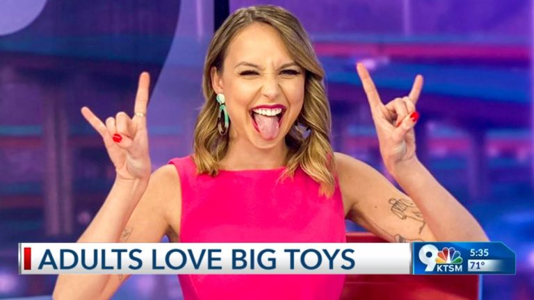 Woman in pink making rock gesture on TV