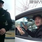 Police officer interacting with person in car.