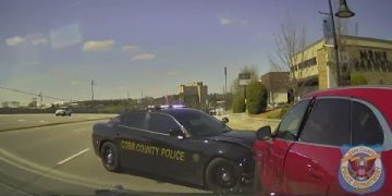 Police car ramming red vehicle on city street.