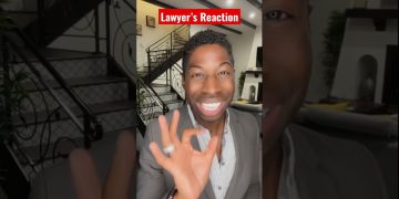 Smiling person gives okay gesture indoors.