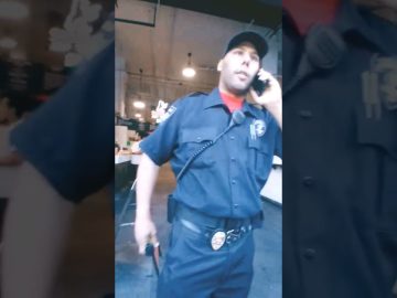 Security officer talking on phone inside building.