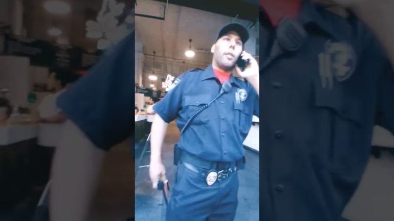 Security officer talking on phone inside building.
