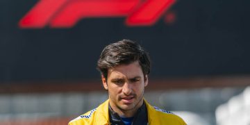 Man in yellow jacket, Formula 1 logo background.