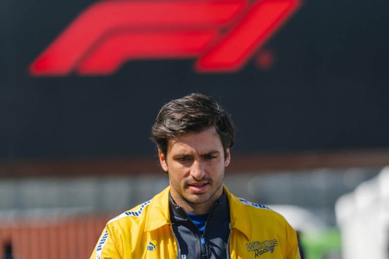 Man in yellow jacket, Formula 1 logo background.