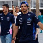 Two race team members walking in paddock.