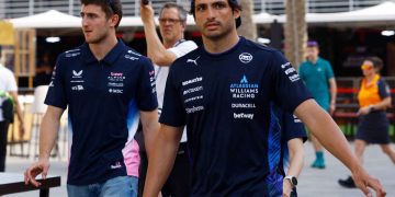 Two race team members walking in paddock.