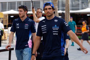 Two race team members walking in paddock.