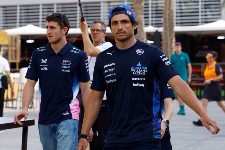 Two race team members walking in paddock.