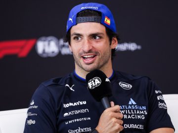Race car driver speaking at press conference.