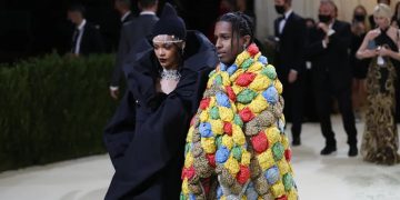 Fashionable couple at elegant event in creative outfits.