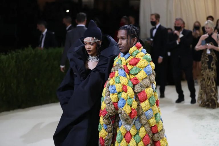 Fashionable couple at elegant event in creative outfits.