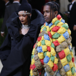 Fashionable couple at a gala in elaborate outfits.