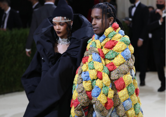 Fashionable couple at a gala in elaborate outfits.