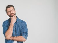 Thoughtful person in denim shirt, looking contemplative.