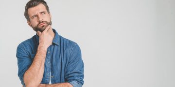 Thoughtful person in denim shirt, looking contemplative.