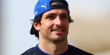 Smiling man wearing a blue cap outdoors.