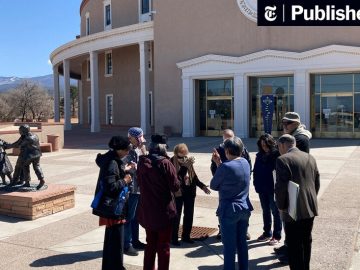 Group gathered outside historic building with statues.