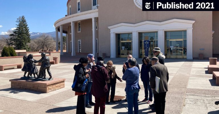 Group gathered outside historic building with statues.